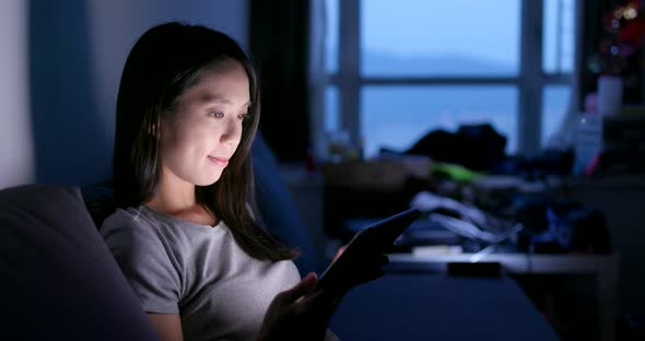 Woman use of smart phone in the evening at home