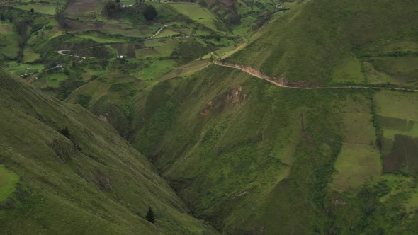 Flying backwards to show the area of a valley with meadows and houses