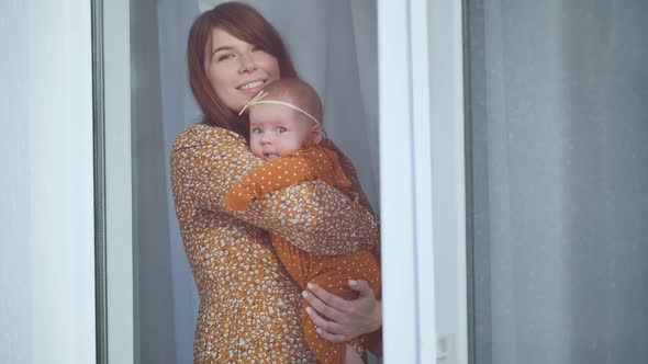 A Loving Mother with a Baby Outside Her Window