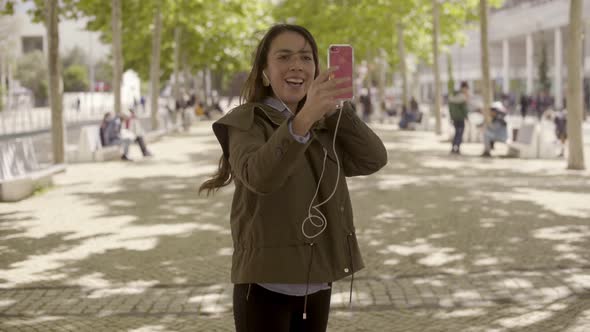 Happy Young Woman Talking on Phone Outdoor During Sunny Day