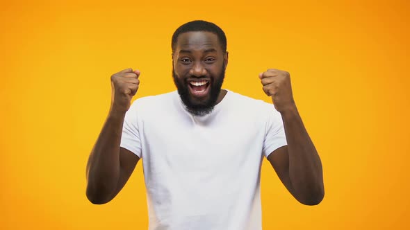 Young Black Guy Making Success Gesture With Hands, Isolated on Yellow Background