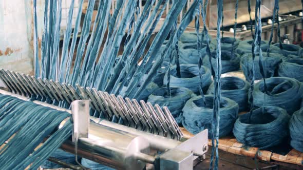 Coloured Yarn is Getting Unwound By a Factory Mechanism