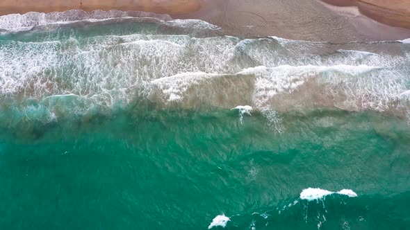 Aerial View of the Mediterranean Coast Waves Reach the Deserted Sandy Beach