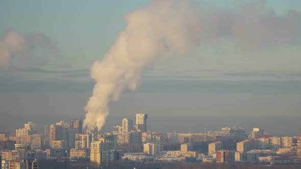 City Pipes Emit Steam Into the Atmosphere Against the City Skyline 15