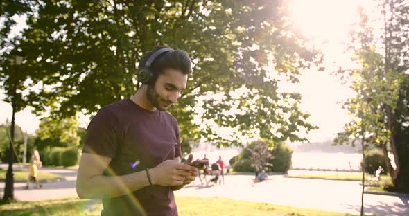 Pakistani Young Man Listening to Music in a Green Park