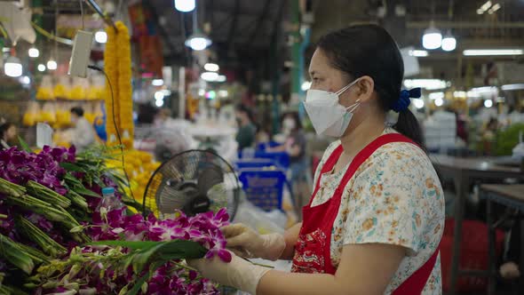 Asian Florist Wearing Protective Facemask While Making Bouquet For Sale In Bangkok Flower MarketPak