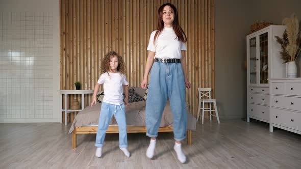 Joyful Mother and Kid in Jeans Dance and Give High Five