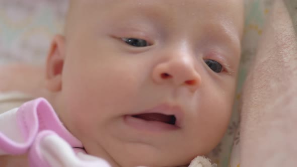 A closeup of a yawning baby girl face