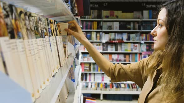 A Young Girl Chooses a Book in a Bookstore