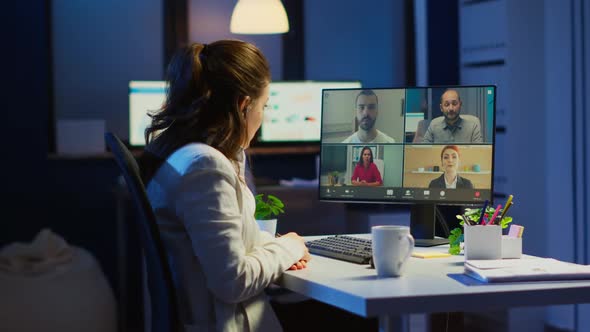 Employee Discussing with Partners Online Using Webcam at Night