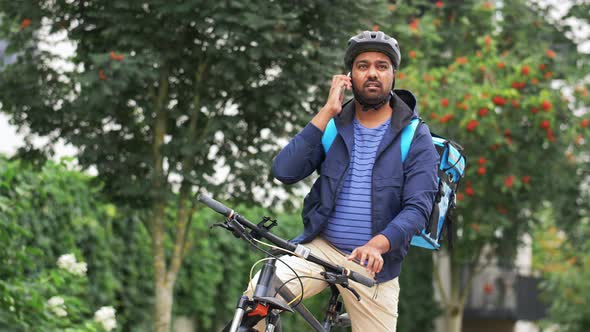 Delivery Man with Bag and Bicycle Calling on Phone