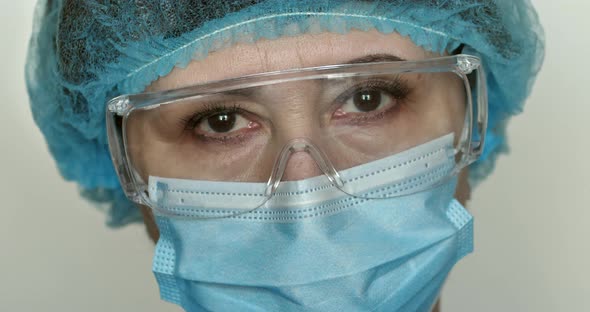 Closeup portrait of an experienced Caucasian female surgeon, doctor with mask ready for work in a h.