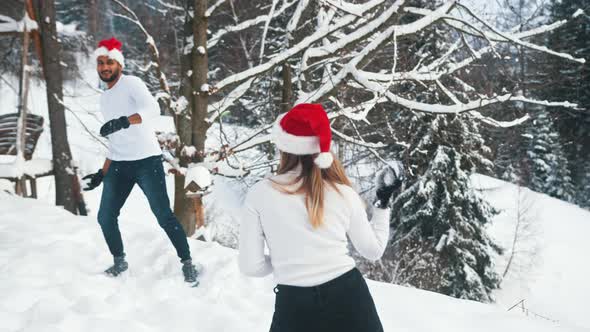 Happy Young Couple Dancing with Christmas Lights and Santa Hats