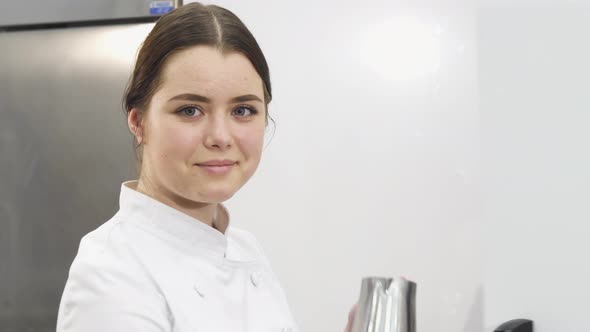 Beautiful Female Chef Smiling To the Camera While Working on Her Kitchen