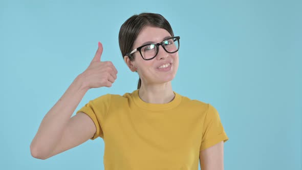 Positive Young Woman Doing Thumbs Up on Purple Background 