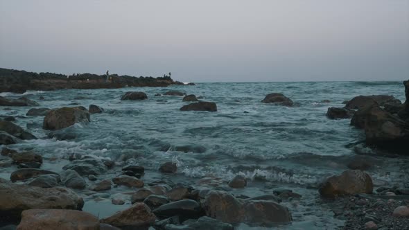 Strong waves on the beach with rock cliff and stormy waves