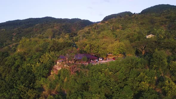 Aerial footage flying up and over a small coastal town in the Oslob region of the Philippines at sun