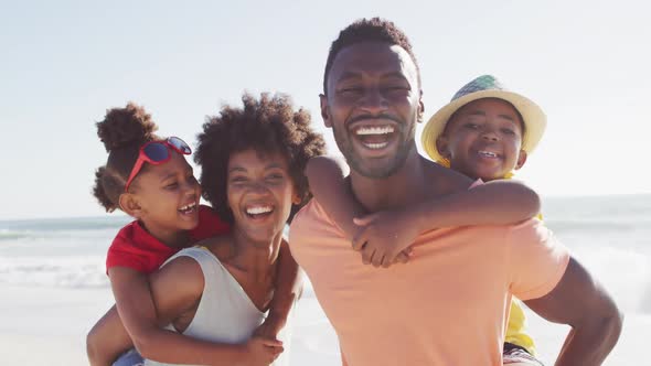 Portrait of smiling african american family embracing on sunny beach