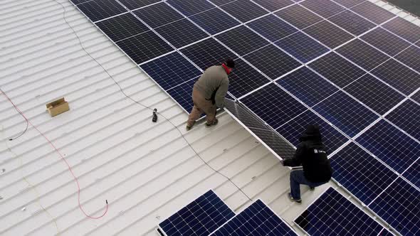 Solar Technician Installing Solar Panels on House Roof