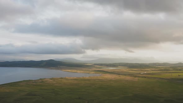 Drone View of a Sunset in a Valley with a River and Mountain Ranges