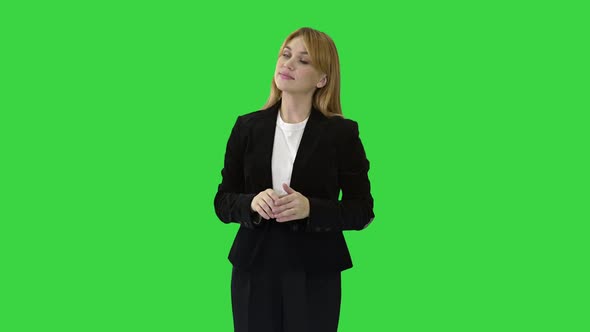 Young Business Woman Presenting Something Pointing at Virtual Objects To Her Sides on a Green Screen