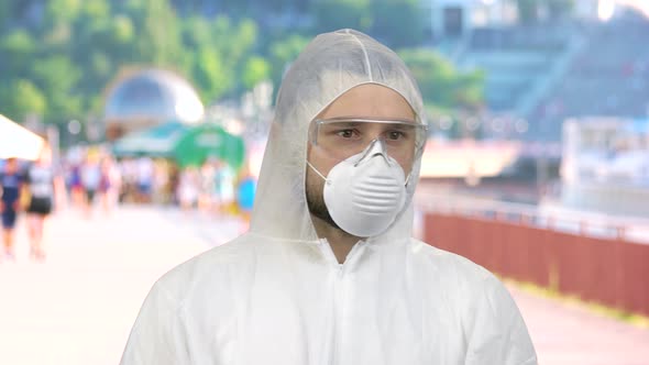 Portrait of Man Wearing Respiratory Mask and Protective Suit Standing Outdoors and Looking Around