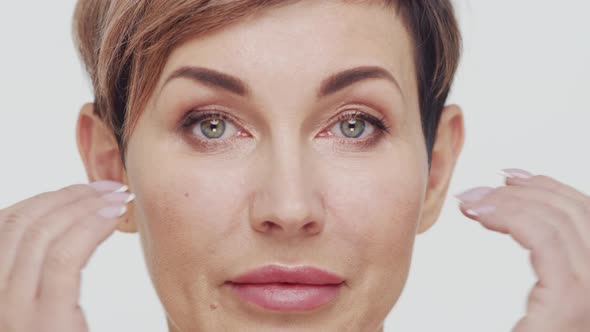 Close-up of middle aged mature woman over white background.