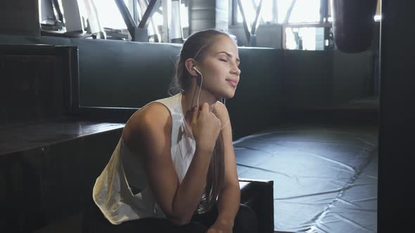 Cheerful Young Fitness Woman Enjoying Listening Music at the Gym