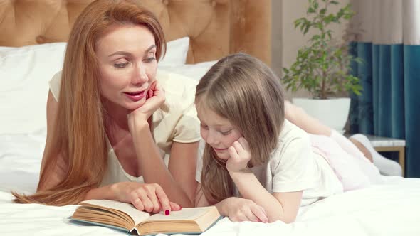 Adorable Little Girl Learning Reading at Home with Her Mother