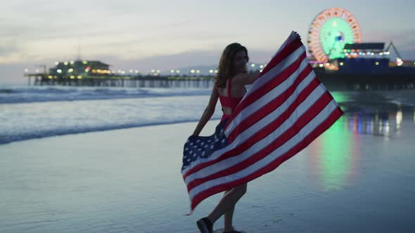 Evening walk on Santa Monica beach, while holding the US flag