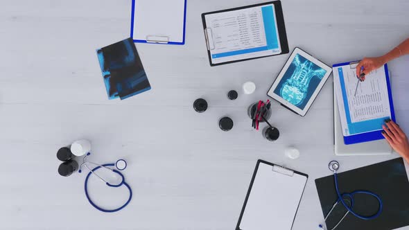 Doctor Checking Medical Record on Desktop Top View