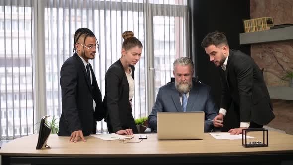 Solid mature man, the director of the company talks to his employees in office