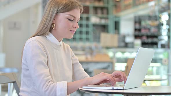 Young Woman Going Away By Closing Laptop in Cafe 