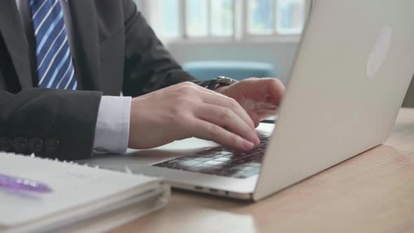 Close Up Of Asian Businessman Wearing Business Suit Typing On Computer While Working At Home