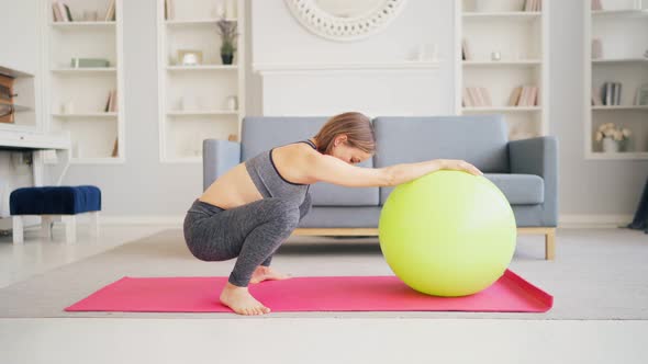 Pregnant Woman Exercise With Pilates Ball In A Living Room