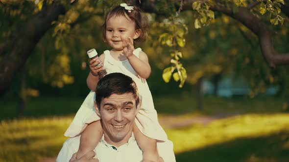 Little Girl Sitting on Daddy's Shoulders