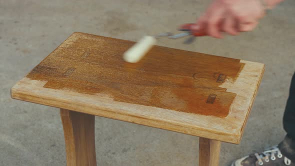 Varnishing small wooden oak table with roller, Timelapse