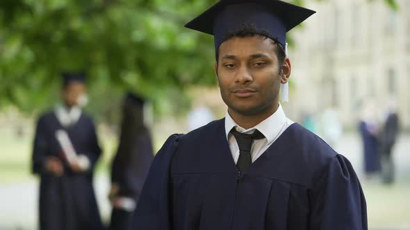 Serious Graduate Crossing Arms With Diploma in Hand, Completion of Studies Pride