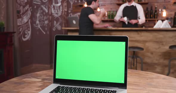 Laptop with Green Scree on a Table