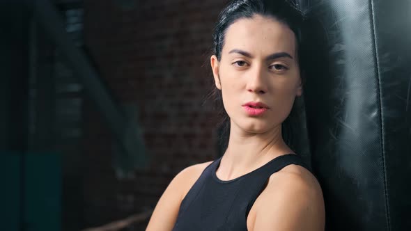 Closeup Portrait of Confident Beautiful Fighter Asian Woman Posing with Punching Bag Zoom in