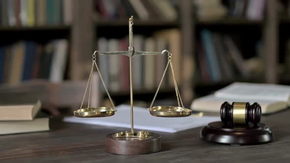 Close Up Shoot of Gavel and Gold Brass Balance Scale on Judge Table