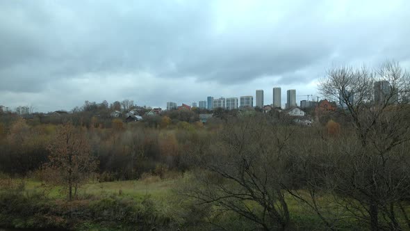 Construction of a city block next to a forested area. Photographed in cloudy weather.