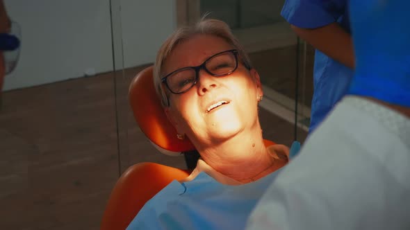 Dentist Technician Lighting the Lamp for Examining Patient