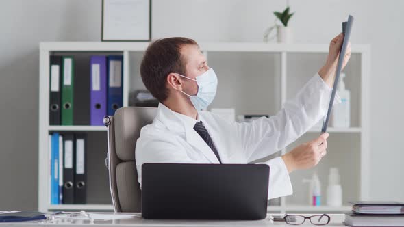 Professional medical doctor working in hospital office using computer technology.