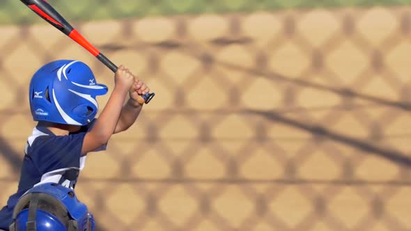 A batter is at bat while playing in a boys little league baseball game.