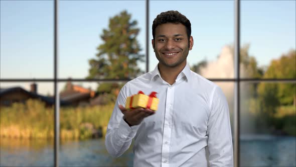 Smiling Businessman Presenting Gift Box.