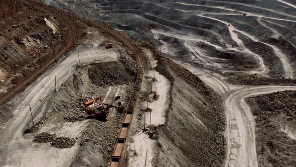 Large Excavator Loads Rock Formation to the Freight Train