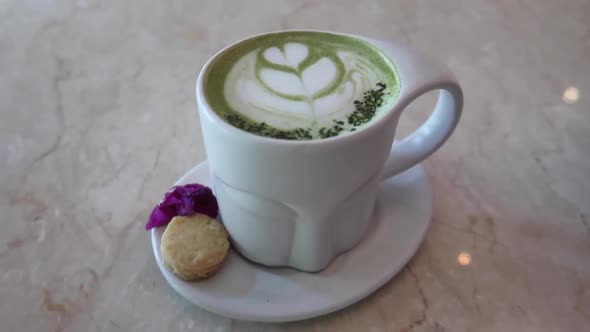 Hot Matcha Green Tea Latte Art in a Buddha Design Zen Mug with Cookie