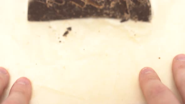 A Large Piece of Chocolate on Wrapping Paper Appears in the Frame Closeup