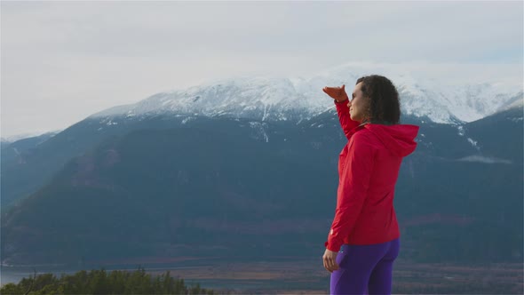 Adventurous Girl Hiking in the Mountains During a Sunny Winter Sunset